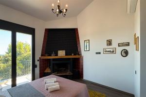 a living room with a fireplace and a table at Mandarini Luxury Villa Pefkochori 5 bedrooms 12 guests in Pefkohori