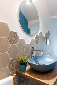 Un baño con un lavabo azul y un espejo. en GIOTTO Guesthouse, en Due Carrare