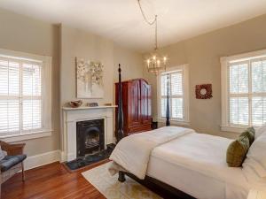 a bedroom with a large bed and a fireplace at Luxury on Lincoln in Savannah +39 photos