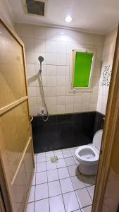 a bathroom with a toilet and a green window at Smart Entry Room Grnada in Riyadh