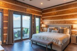 a bedroom with wooden walls and a bed and a balcony at Above and Beyond in Boone