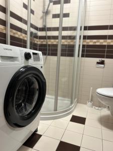 y baño con ducha y lavadora. en Chodorowska Home, en Świnoujście