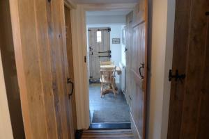 ein Flur mit zwei Türen und einem Tisch in einem Zimmer in der Unterkunft Weavers Cottage in Southwold + 29 Fotos