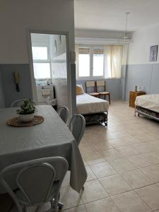 a room with two beds and a table and chairs at Excelente apartamento centrico, a una cuadra de la playa in Mar del Plata