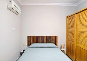 een slaapkamer met een bed met een houten hoofdeinde bij Ilha Flat 4-106 in Ilhabela +18 foto's