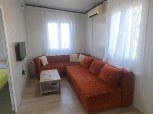 a living room with a red couch and a table at Auto camp Čarobna ravnica in Podgorica