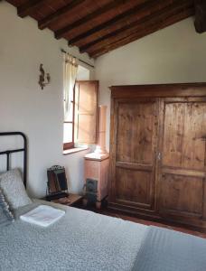 a bedroom with a bed and a wooden cabinet at HILL's ROOM in Vescona
