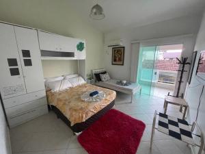 a bedroom with a bed and a table in it at A Pérola do Gravatá in Navegantes