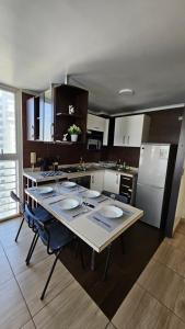 a kitchen with a table with plates on it at Departamentos Amoblados R&M in Santiago