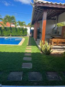 un giardino con passerella accanto a una casa di Casa de Mônica a Camassari