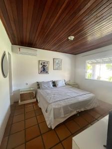 una camera da letto con un letto con soffitto in legno di Casa de Mônica a Camassari