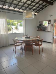 una sala da pranzo con tavolo e sedie di Casa de Mônica a Camassari Altre 7 foto