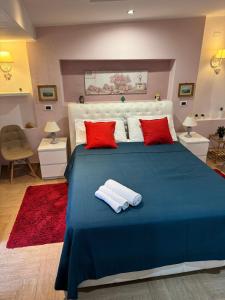 1 dormitorio con cama azul y almohadas rojas en Casa Etna Soul, en Paterno