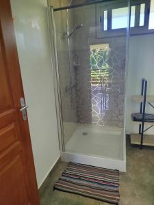 - une douche dans une chambre avec une porte en verre dans l'établissement 3R Lodge Bungalows, à Toanoano