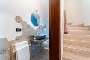 Un baño con un lavabo azul sobre un tocador y escaleras. en GIOTTO Guesthouse, en Due Carrare