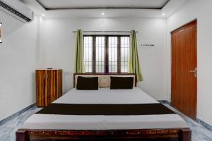 a bedroom with a large bed with a window at Hotel O Ujala Guest House in Varanasi