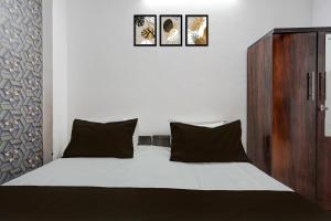 コーターにあるHotel O Shri Panchmukhi Residency Baran Roadのベッドルーム1室(壁に3枚の写真が飾られたベッド1台付)
