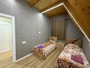 a room with two beds and a staircase in it at bag evi in Mardakan