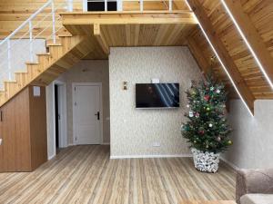 a christmas tree in a living room with a staircase at bag evi in Mardakan