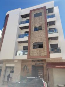 a building with a car parked in front of it at Appartement Ennour de Martil in Martil