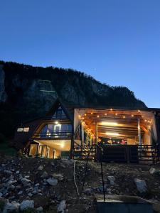 a wooden cabin with lights on it at night at A-Frame Retreat Vulcan in Vulcan