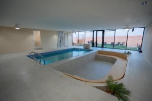 a large room with a swimming pool in a building at Marbella bungalows desert private camp in Bidiyah