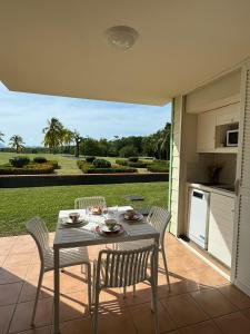 Una mesa y sillas en un patio. en Appartement Ti-Paradis - RDC, en Sainte-Luce