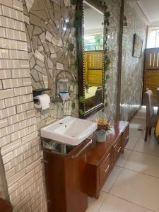 a bathroom with a sink and a mirror at Ma'a Lapseu hôtel in Yaoundé