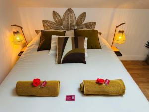 a white bed with two red roses on it at Le Champêtre - Centre du Rheu in Le Rheu