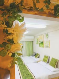 a room with four beds with yellow flowers on the wall at Shinjuku Downtown新宿 in Tokyo