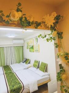 two beds in a room with flowers on the ceiling at Shinjuku Downtown新宿 in Tokyo
