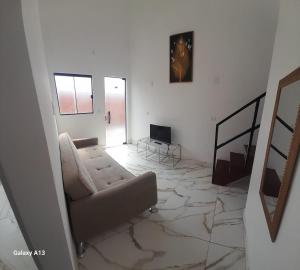 Una sala de estar con un sofá y un televisor. en Casa completa, 2 quartos, com ar condicionado, en Hortolândia