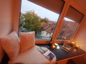 Schlafzimmer mit einem großen Fenster mit Stadtblick in der Unterkunft Königstraße Apartments in Nürnberg