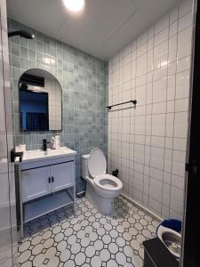 Un baño con inodoro, lavabo y espejo. en Mango Hostel - 420 Friendly, en Bangkok