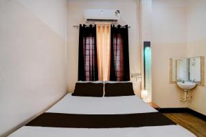 a small bedroom with a bed and a sink at Collection O GNRC Hospital Dispur Formerly Shree Vinayak Guest House in Guwahati