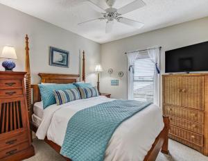ein Schlafzimmer mit einem Bett und einem Flachbildfernseher in der Unterkunft Sandpiper Seaview 201 in Tybee Island