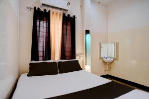 a bedroom with a white bed and a window at Collection O GNRC Hospital Dispur Formerly Shree Vinayak Guest House in Guwahati