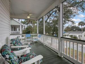 weranda z białymi krzesłami, stołami i oknami w obiekcie Life's a Beach w mieście Tybee Island