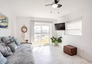 a living room with a couch and a ceiling fan at Oasis Waterfront Treasure Island Apartment with Patio Dock and Johns Pass in St Pete Beach