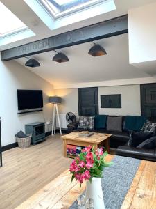 a living room with a couch and a table at 89a Church Street - Luxury One Bed Apartment with Roof Terrace in Whitby