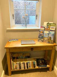 a wooden table with books and a laptop on it at 89a Church Street - Luxury One Bed Apartment with Roof Terrace in Whitby