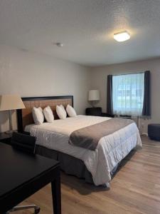 a bedroom with a bed and a desk and a window at The Lake Huron Resort in Oscoda
