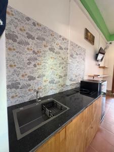 a kitchen with a sink and a black counter top at Por Chey Residence in Battambang +11 photos