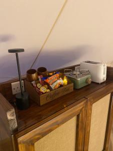 a counter top with a box of food and a toaster at Sahara Dream Camp in Al Raka