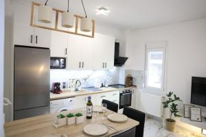 a kitchen with a wooden table and a kitchen with white cabinets at Modern Apartment G66 in the Center in Drama