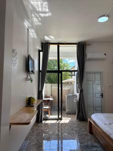 a bedroom with a bed and a sliding glass door at Por Chey Residence in Battambang