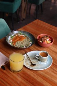 una mesa con platos de comida y un vaso de jugo de naranja en Hotel Kavia Premium - Paseo Montejo, en Mérida