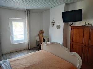a bedroom with a bed and a flat screen tv at Chez Christine et Fred in Villedaigne