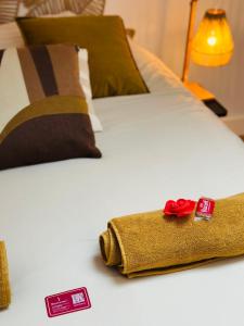 a bed with a towel and a red rose on it at Le Champêtre - Centre du Rheu in Le Rheu