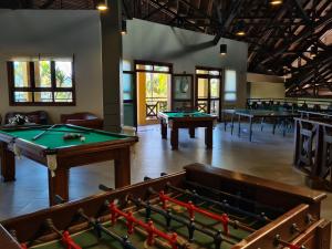 a room with a pool table and several tables at FLAT ILHA FLAT HOTEL in Ilhabela